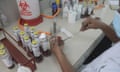 The hands of a person can be seeding a culture. Other scientific equipment such as phials and a bunsen burner can be seen on the desk