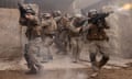 actors playing soldiers, guns raised, walking towards the viewer
