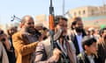 Several men brandish assault rifles while a boy looks on