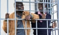 Kizza Besigye Obeid Lutale stand in a steel dock during court proceedings