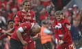 Arne Slot gets a champagne shower from Virgil van Dijk and Harvey Elliott (right) after securing the title.