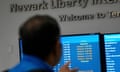 a man pointing to a screen that shows mostly delayed flights